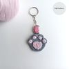 Crochet_Cat_Paw_on_a_White_Background_with_a_Pink_Keychain_1.jpg