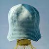 A bell hat made of linen fabric with a houndstooth print. Panama hat with a pied-de-poule print. Mint panama hat  tulip.