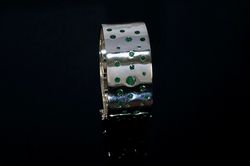 silver bangle with emerald gemstones