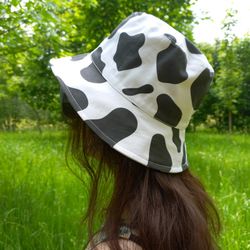 bucket hat with cow print made of cotton. fashionable unisex bucket hat. cute animal print hat. summer hat for travel.