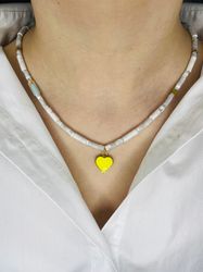 grey necklace with a yellow heart pendant