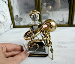 an empty glass bottle with a figure of an octopus and a starfish on the lid