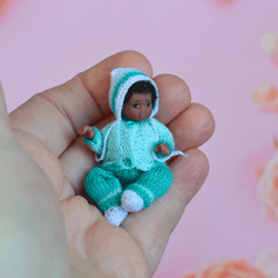 miniature doll child in 12th scales. a baby for the dollhouse. baby in a blue suit.