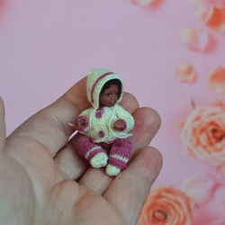 miniature doll child in 12th scales. a baby for the dollhouse. baby in a knitted suit.