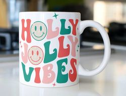 retro christmas coffee mug stating  holly jolly vibes  with smiley faces