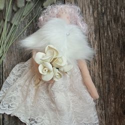 gentle handmade doll angel with a bouquet of white roses