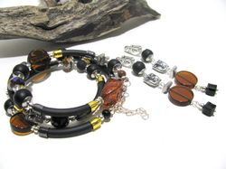 trending contemporary style jewelry set of layered bracelet and earrings, black rubber bracelet