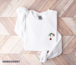 grinch hand with christmas bauble embroidered sweatshirt