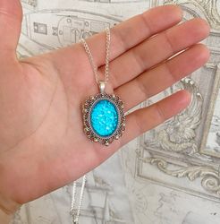 Bright, turquoise pendant on a handmade cord. Handmade jewelry with turquoise rhinestones.