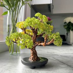 handcrafted artisan shimmering green artificial tree with realistic trunk