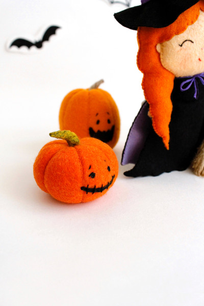 Felt Halloween pumpkins near the witch with a broomstick