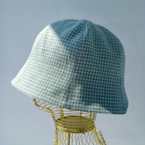 A bell hat made of linen fabric with a houndstooth print. Panama hat with a pied-de-poule print. Mint panama hat  tulip.