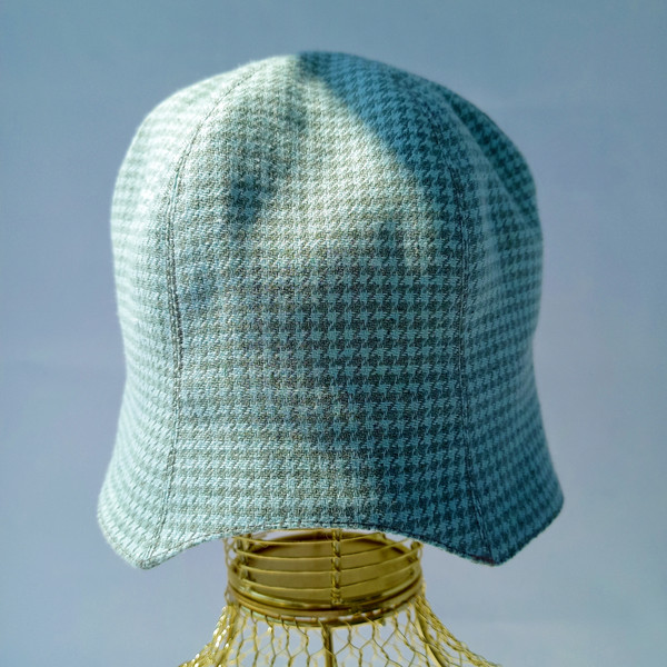 A bell hat made of linen fabric with a houndstooth print. Panama hat with a pied-de-poule print. Mint panama hat  tulip.