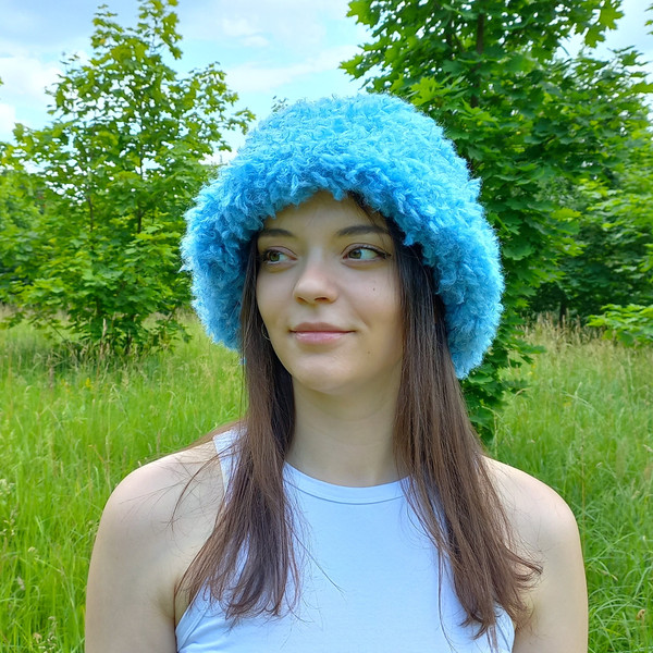 Cute bucket hat. Style curly hat. Bright blue fluffy fur panama hat.