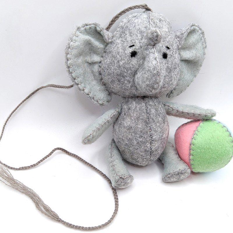 Grey elephant made of felt with a ball.jpg
