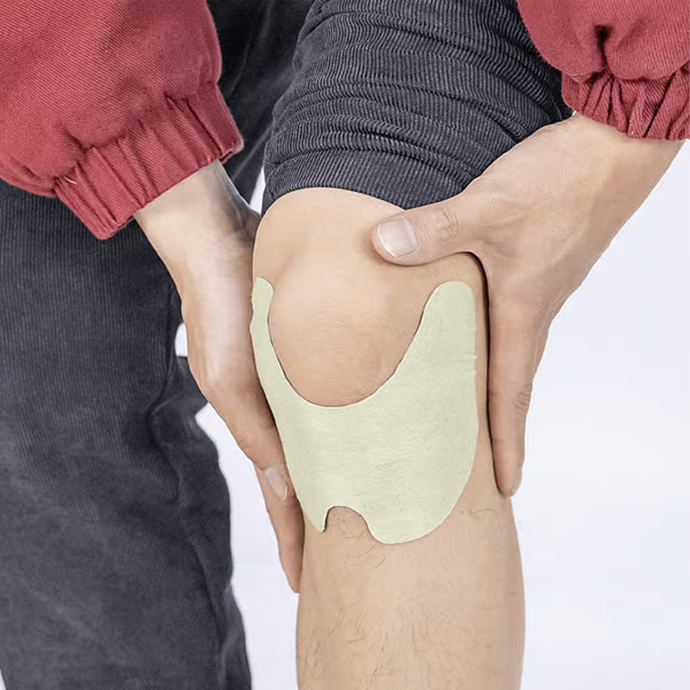 Natural knee pain relief patch being applied smoothly