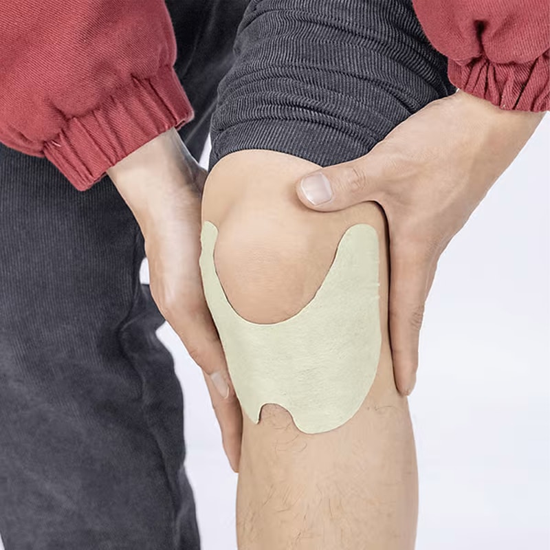 Natural knee pain relief patch being applied smoothly